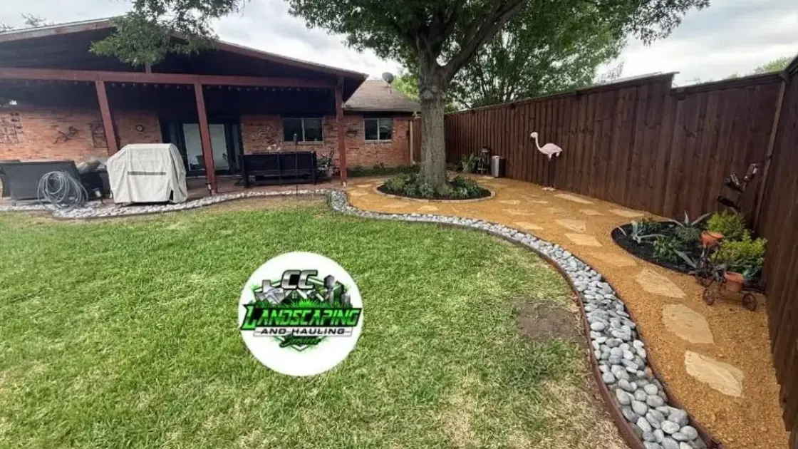 Curved stone border around a rock bed with plants beside a brick house