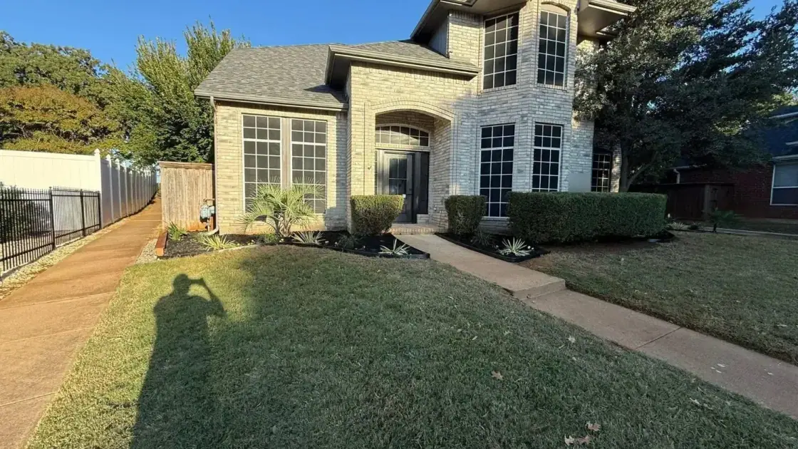 Brick home with trimmed shrubs and freshly mulched front beds